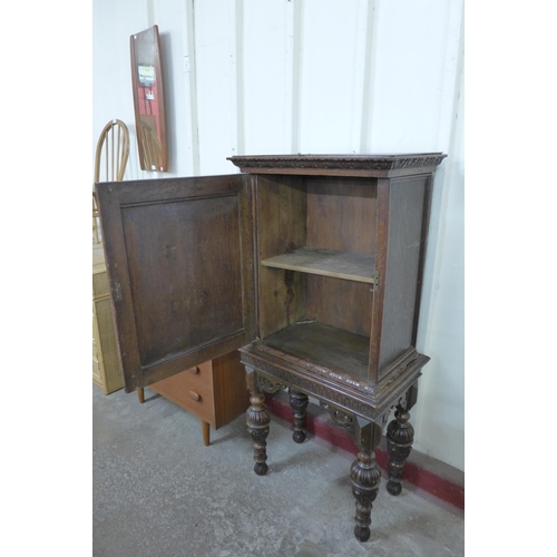 228 - An Elizabethan Revival carved oak geometric moulded cupboard on stand