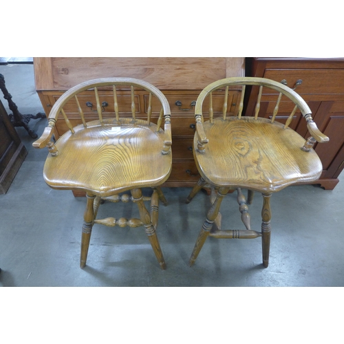 268 - A pair of elm saddle seat revolving bar stools