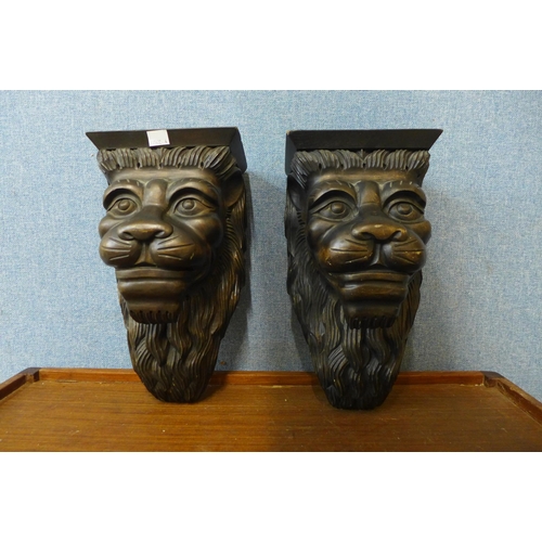 358 - A pair of carved wood lion's face wall brackets