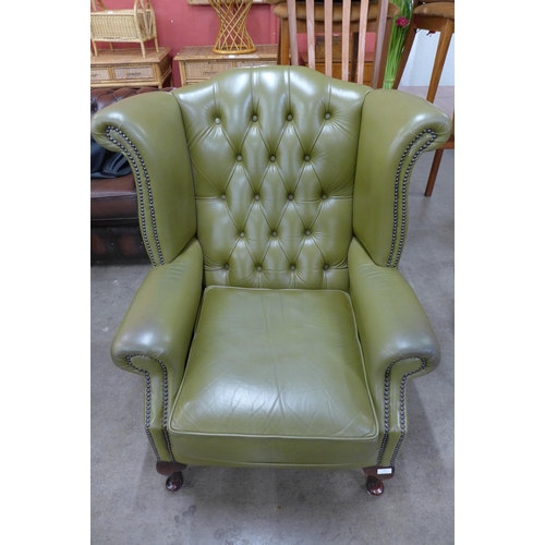 57 - A green leather Chesterfield wingback armchair