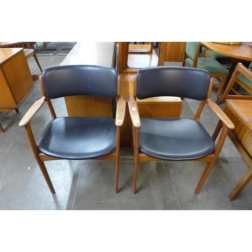 98 - A pair of Danish Oddense Maskinsnedkeri teak and black vinyl elbow chairs, designed by Erik Buch