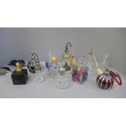 695 - A collection of perfume atomisers and other glass bottles, including one silver topped