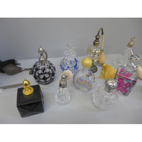 695 - A collection of perfume atomisers and other glass bottles, including one silver topped