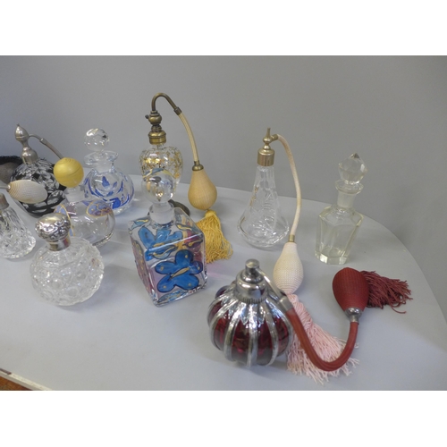 695 - A collection of perfume atomisers and other glass bottles, including one silver topped