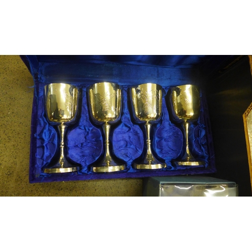 704 - A collection of silver plated cups, claret jug, decanters, etc.