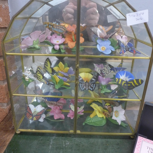 772 - A porcelain sculpture collection, The Butterflies of the World in a glazed cabinet