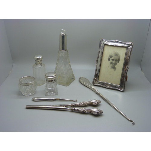 829 - A silver photograph frame, a/f, silver mounted bottles, glove stretchers, etc.