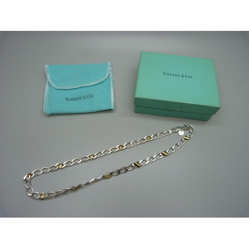 894 - A Tiffany & Co. silver necklet interspersed with 18ct gold mounts, boxed with pouch, 23g