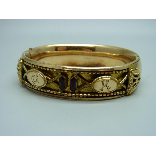 907 - A Victorian bangle set with two garnets, marked 'Gold Shell', with initials