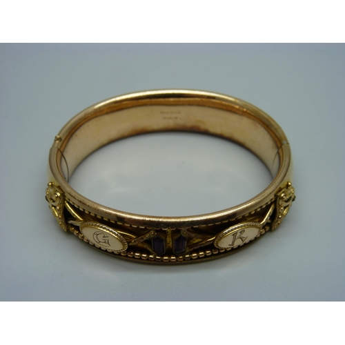 907 - A Victorian bangle set with two garnets, marked 'Gold Shell', with initials