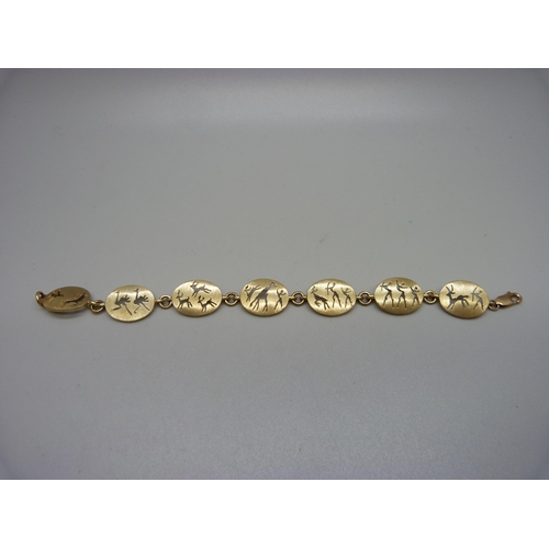 913 - A 9ct gold seven panel bracelet depicting ostrich, deer, giraffe, tribesmen, etc., 15.5cm