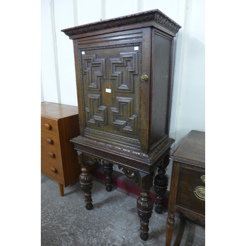 137 - An Elizabethan Revival carved oak geometric moulded cupboard on stand