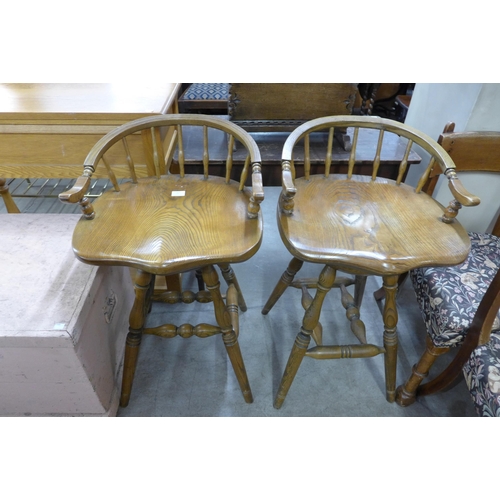 167 - A pair of elm saddle seat revolving bar stools