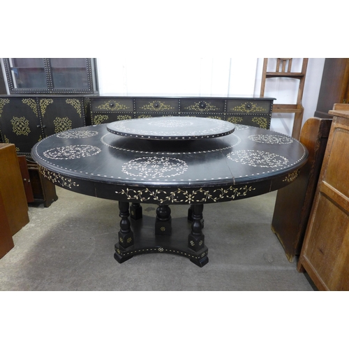 192 - An eastern ebonised and faux ivory inlaid dining suite, comprising of circular dining table, lazy Su... 