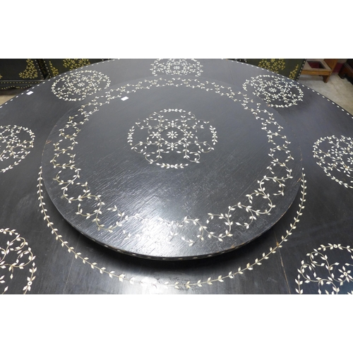 192 - An eastern ebonised and faux ivory inlaid dining suite, comprising of circular dining table, lazy Su... 