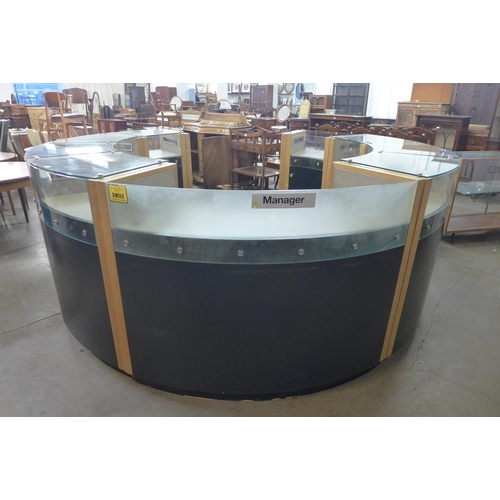 219 - A large circular glazed oak and black glass shop showroom counter