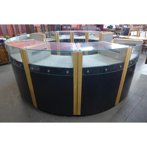 219 - A large circular glazed oak and black glass shop showroom counter