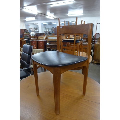 35 - A Nathan teak circular extending dining table and four chairs