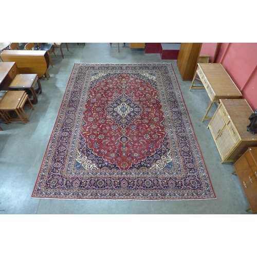 56 - A large Persian red ground Kashan rug, 400 x 292cms