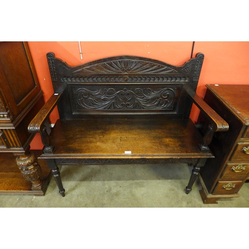 69 - A Jacobean Revival carved oak hall seat