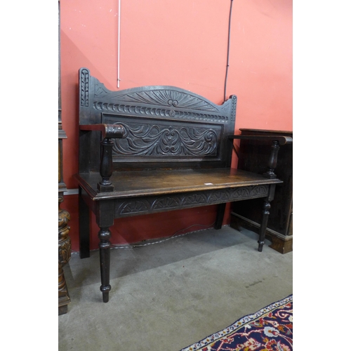 69 - A Jacobean Revival carved oak hall seat