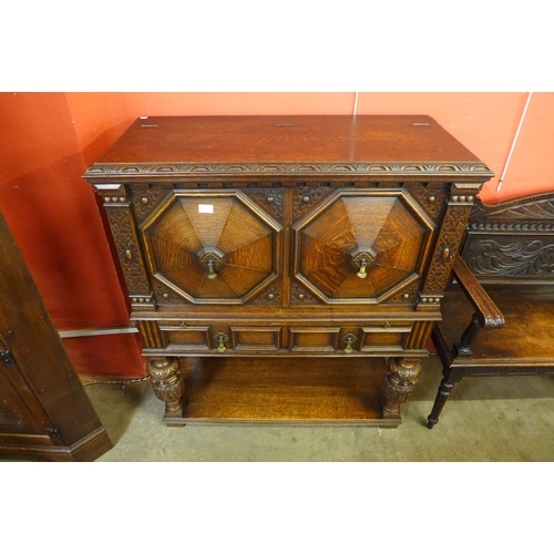 70 - An Elizabethan Revival carved oak geometric moulded cocktail cabinet