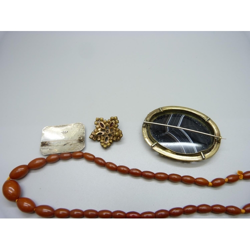 1001 - An amber coloured bead necklace, a Siam silver brooch, a Victorian agate set large brooch and a garn... 