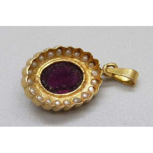 1004 - An 18ct gold pendant set with a cabochon red stone and seed pearls, 6g, 15mm wide