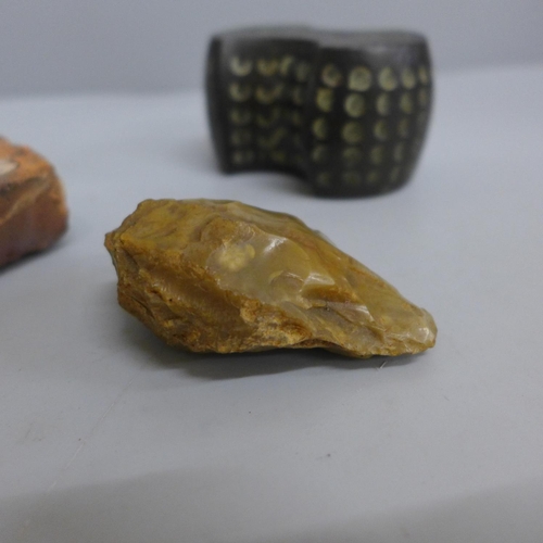 626 - A Paleolithic hand axe, a section of a tile from Bretby House, and a cast bronze weight