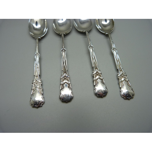 881 - A silver fork and a set of four silver spoons with golf detail, 157g