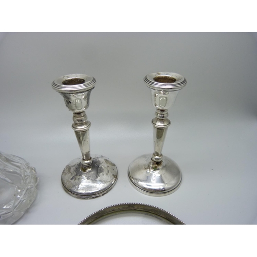 923 - A silver topped scent bottle, a pair of silver candlesticks, a/f, a magnifying glass a/f and a salts... 