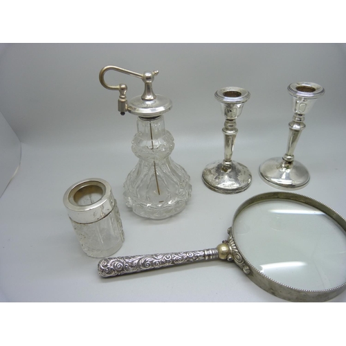 923 - A silver topped scent bottle, a pair of silver candlesticks, a/f, a magnifying glass a/f and a salts... 