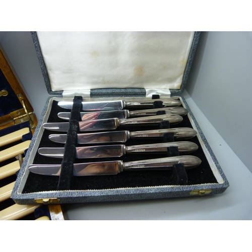 954 - A set of silver handled knives, 1935, and a set of knives and forks with silver ferrules in a wooden... 