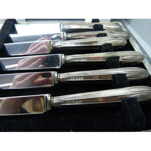 954 - A set of silver handled knives, 1935, and a set of knives and forks with silver ferrules in a wooden... 