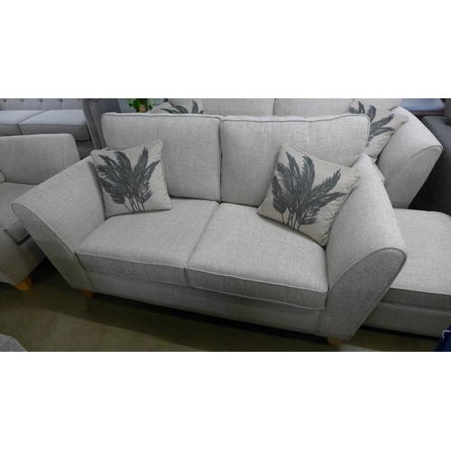 1384 - An oatmeal upholstered three seater, two seater, armchair and footstool