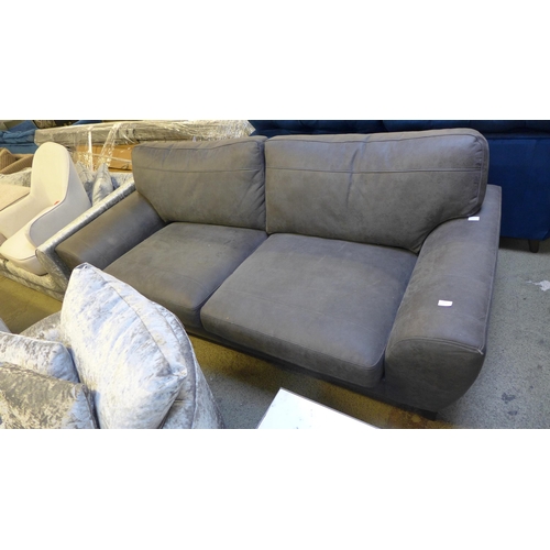 1554 - A grey leather effect three seater sofa - damaged