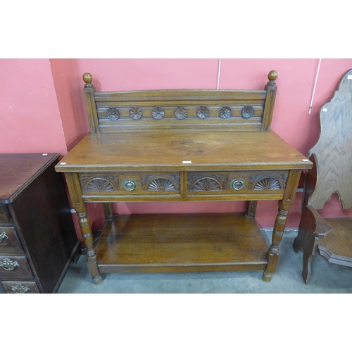 106 - A Victorian Aesthetic Movement carved oak two drawer serving table