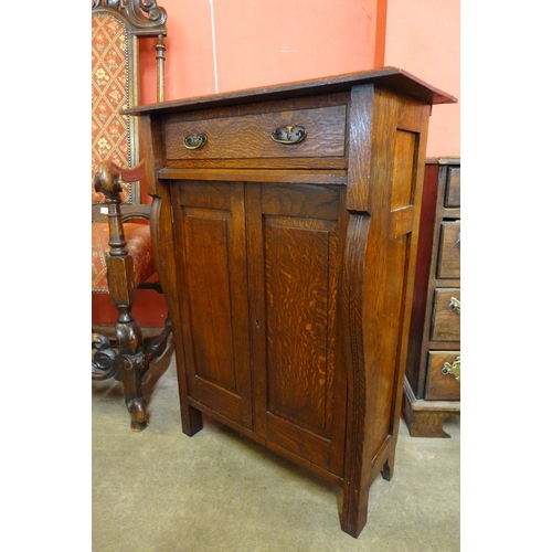 109 - A small Arts and Crafts oak two door cupboard