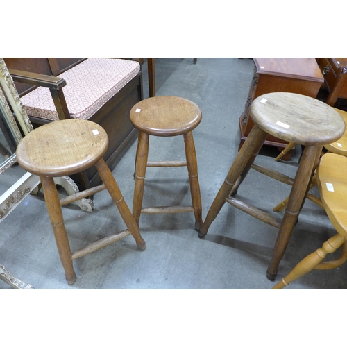 152 - A pair of early 20th Century oak kitchen stools and another