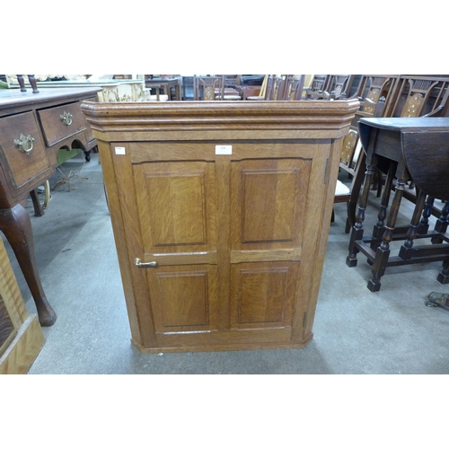 154 - An Arts and Crafts Cotswold School oak wall hanging corner cupboard