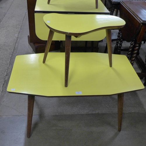 228 - A pair of teak and yellow Formica topped occasional tables, a steel and Formica topped drop-leaf kit... 