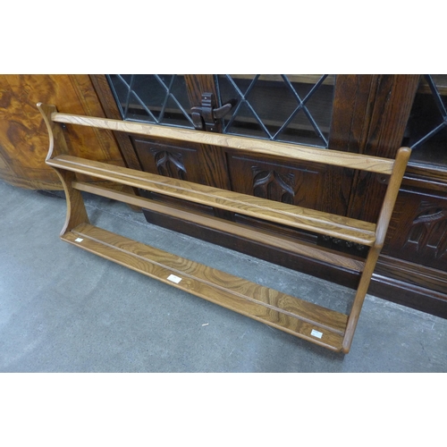 54 - An Ercol elm wall rack