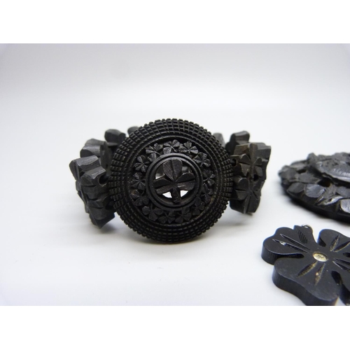 1068 - An Irish bog oak bracelet, a pendant and a carved circular plaque/brooch lacking pin