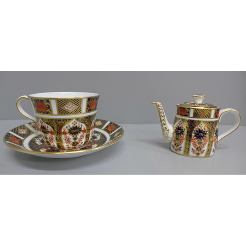 632 - A Royal Crown Derby 1128 pattern cup and saucer and a miniature teapot