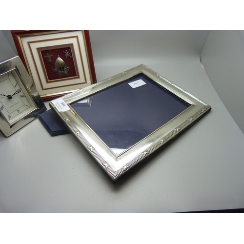 836 - A silver photograph frame, 20.5cm x 25.5cm, a silver framed clock and three small white metal easter... 