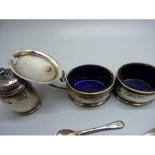 864 - A five piece silver cruet set with three matching spoons and blue glass liners, Birmingham 1928, 165... 