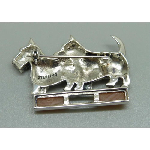 941 - A silver dog brooch with ruby eyes and set with agate, one agate loose