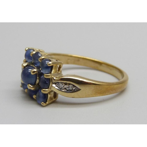 976 - A 9ct gold, nine stone cabochon sapphire ring with diamond shoulders, 3.6g, N