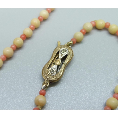 980 - A coral necklace with silver gilt clasp