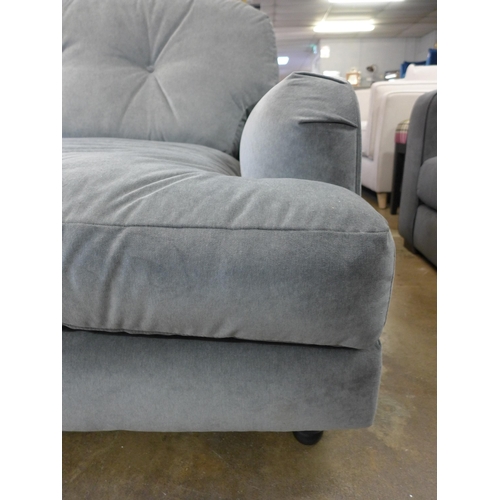 1302 - A grey velvet three seater sofa on turned legs